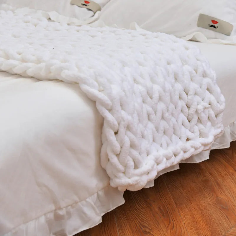 Handmade chunky knitted chenille blanket with cable stitching on sofa