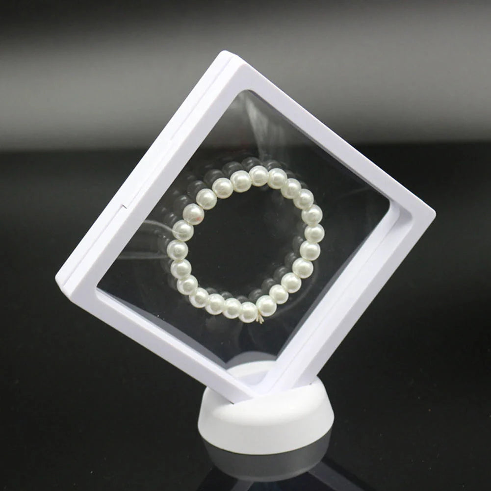 3D floating jewelry coin display stand in white and black, showcasing collectibles in mid-air