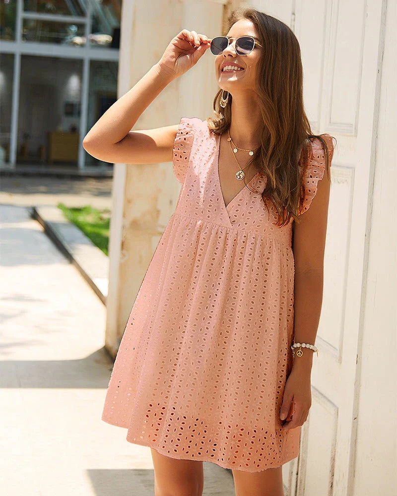 Chic cotton mini dress with floral embroidery and v-neck design for a romantic, summer-ready look
