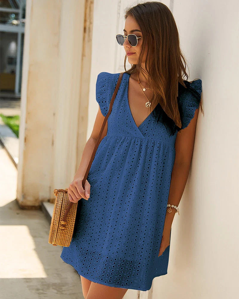 Chic cotton mini dress with floral embroidery and v-neck design for a romantic, summer-ready look