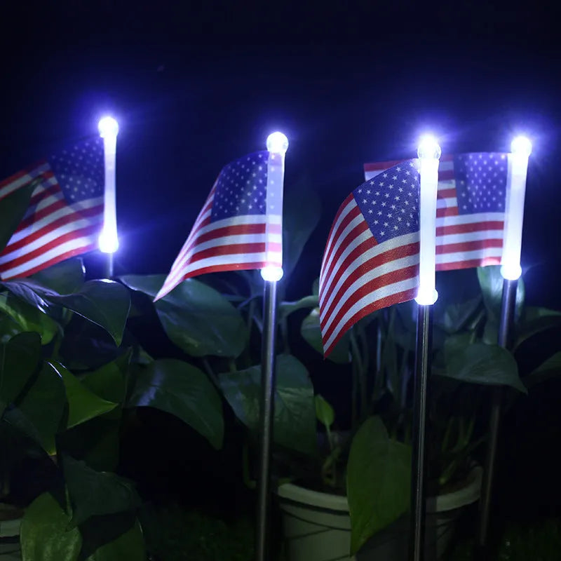 Solar flag light for garden decoration with white LED illumination, featuring American or British flag waterproof fabric designs on stainless steel and plastic construction measuring 34cm tall with polycrystalline solar panel