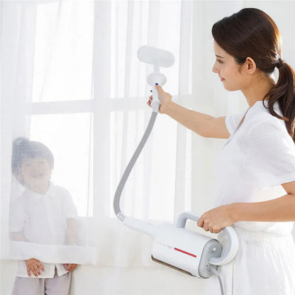 Deerma DEM-ZQ610 white steam cleaner main unit with brush heads, glass scraper, and mop attachments on a table.