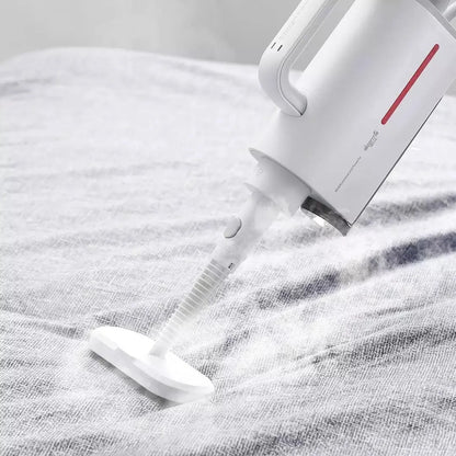 Deerma DEM-ZQ610 white steam cleaner main unit with brush heads, glass scraper, and mop attachments on a table.