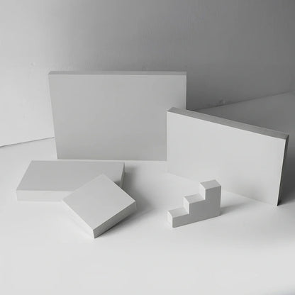 Set of white round and square plastic props for cosmetics shooting, 10cm diameter rounds and 8cm squares for stable product displays