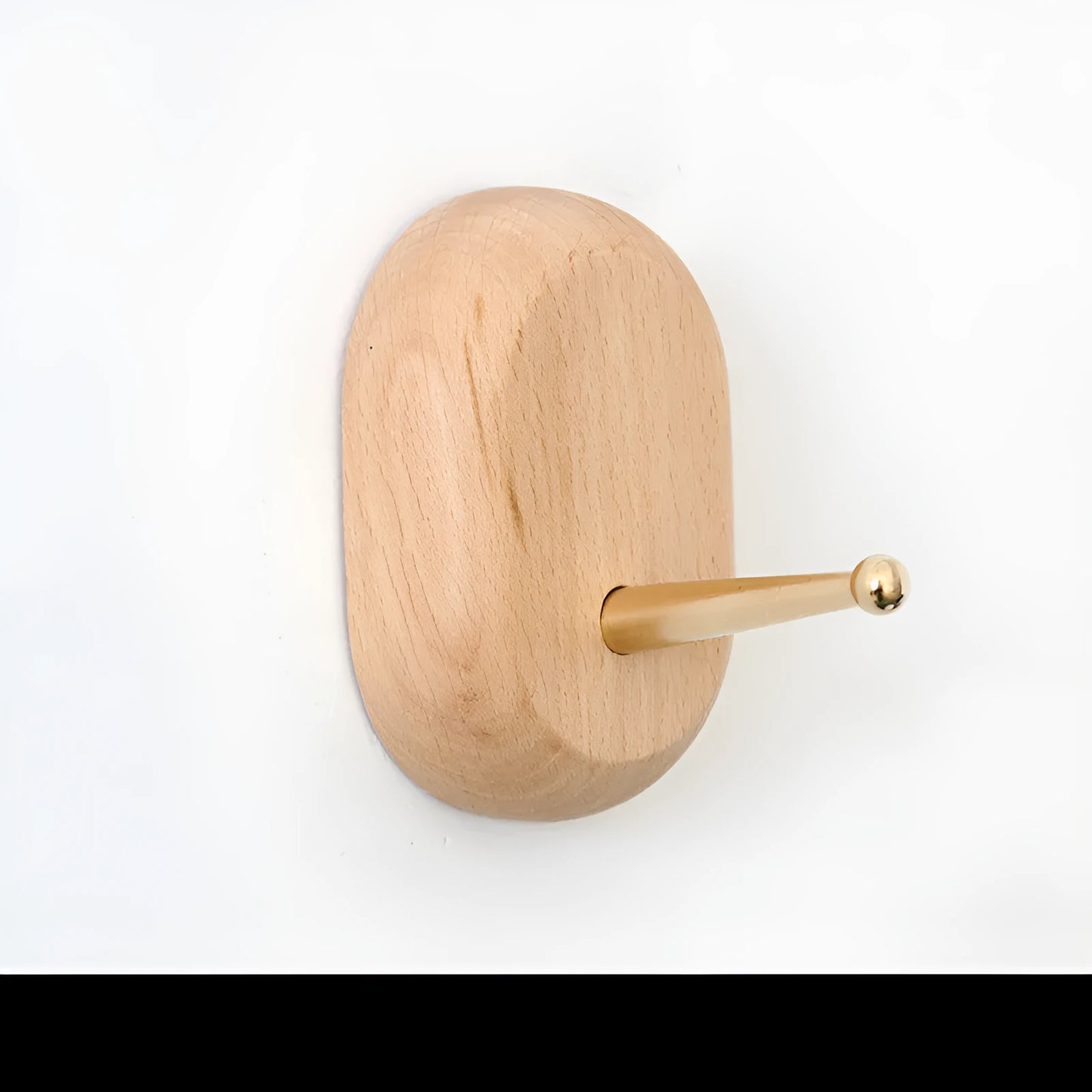 Natural beech wood adhesive wall hook in a capsule shape, shown on a wall for damage-free hanging.