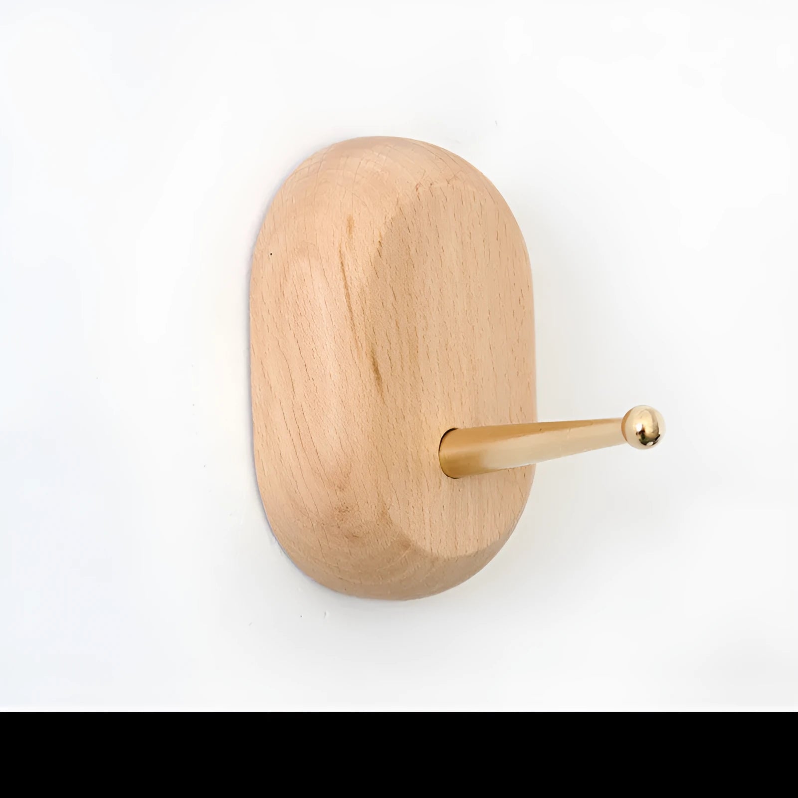 Natural beech wood adhesive wall hook in a capsule shape, shown on a wall for damage-free hanging.