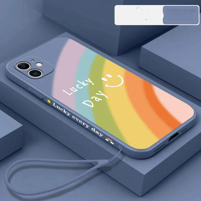 Rainbow smiley silicone phone case for iPhone in blue, showing all-inclusive design and back cover detail.