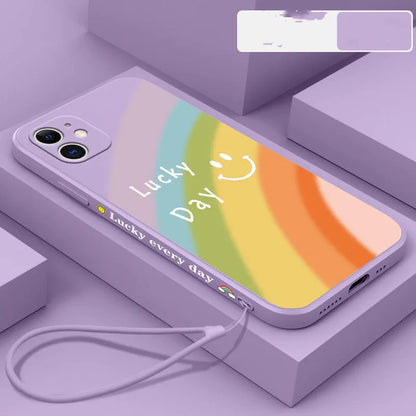 Rainbow smiley silicone phone case for iPhone in blue, showing all-inclusive design and back cover detail.