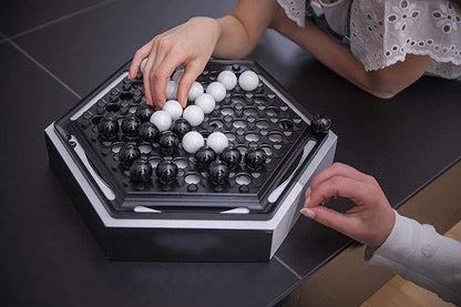 Abalone family board game with marble pieces on a wooden game board