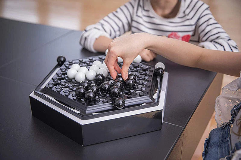 Abalone family board game with marble pieces on a wooden game board