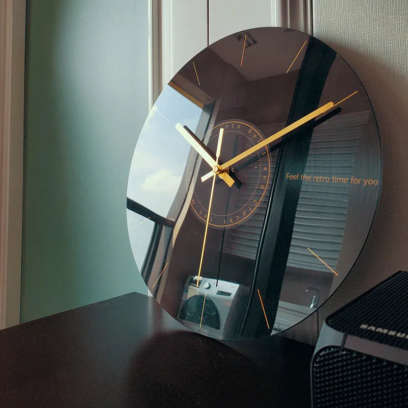 Round silent wall clock with acrylic glass dial, shown in a living room setting.