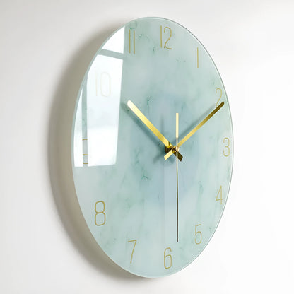 Round silent wall clock with acrylic glass dial, shown in a living room setting.