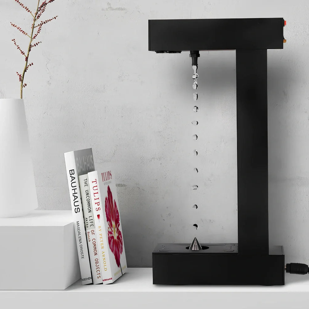 Obsidian black anti-gravity floating sand drop table lamp with geometric hourglass and LED glow