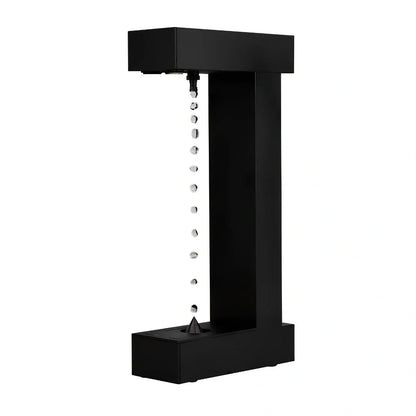 Obsidian black anti-gravity floating sand drop table lamp with geometric hourglass and LED glow
