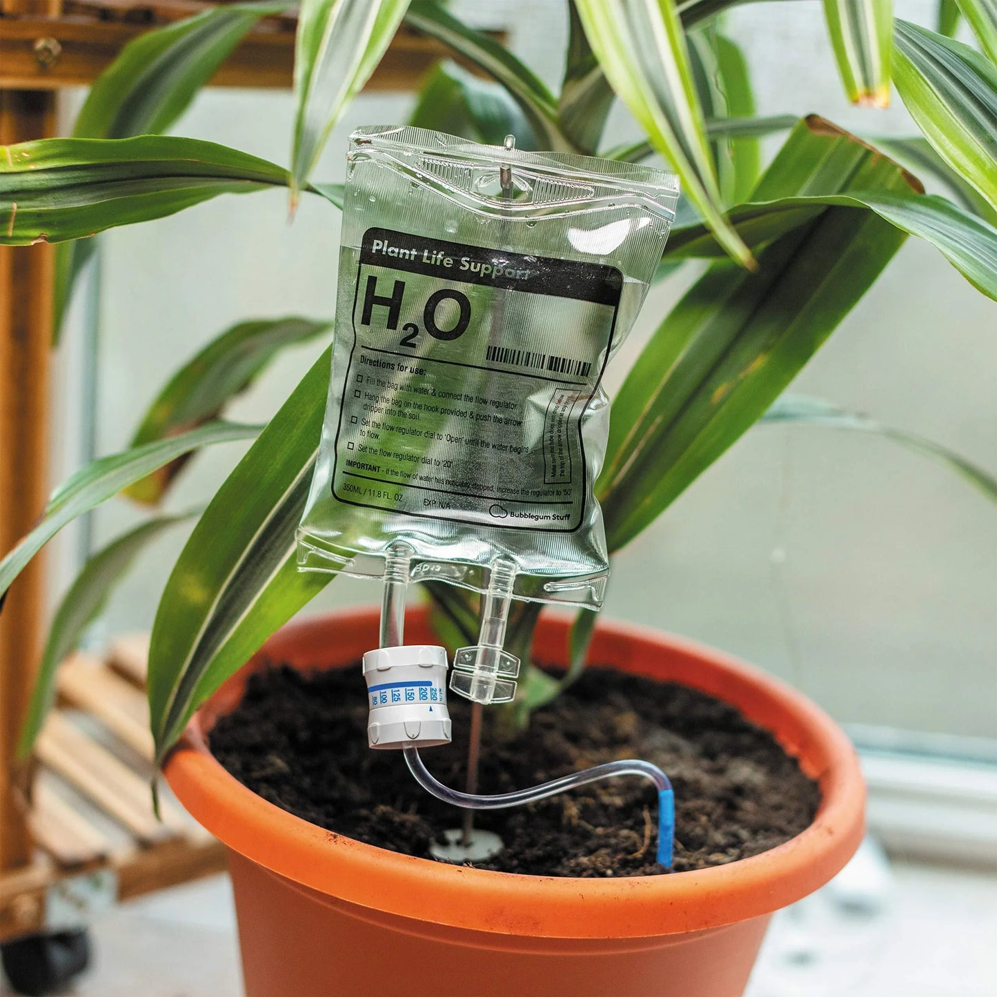 A transparent, self-watering plant feeder device with a 1000ml or 3000ml capacity, designed to keep indoor and outdoor plants hydrated for up to 7 days.