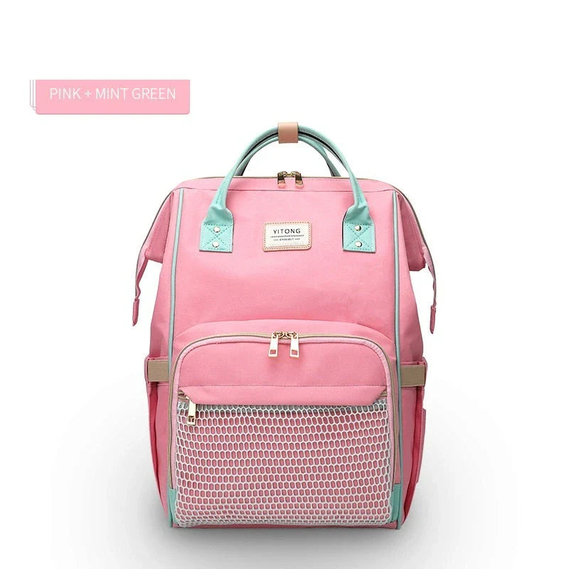 Stylish maternity diaper bag in various colors, featuring a paper bag design, separate bottle compartment, and discreet breastfeeding button.