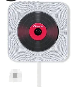 Wall-mounted tray-loading CD player in white colour with remote control on a wooden wall.