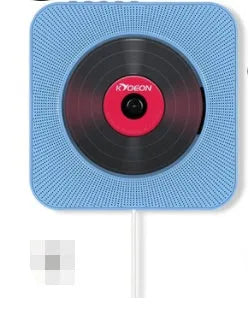 Wall-mounted tray-loading CD player in white colour with remote control on a wooden wall.