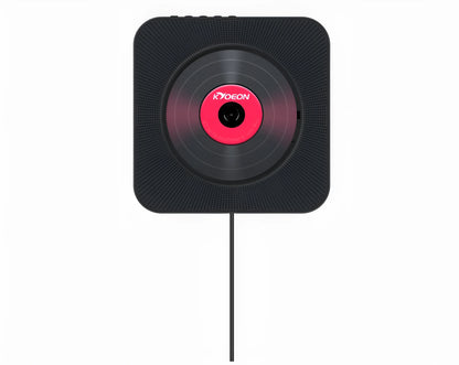 Wall-mounted tray-loading CD player in white colour with remote control on a wooden wall.