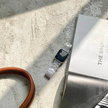 White and grey shell pattern resin Apple Watch strap on a wrist.