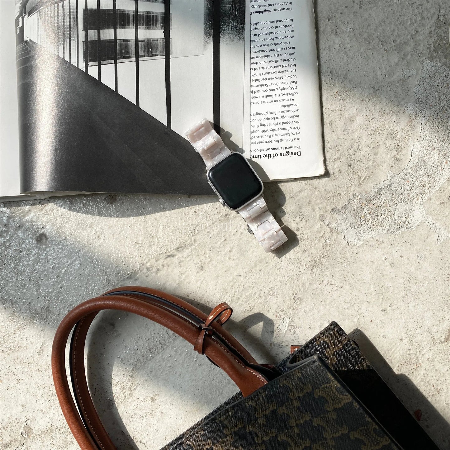 White and grey shell pattern resin Apple Watch strap on a wrist.