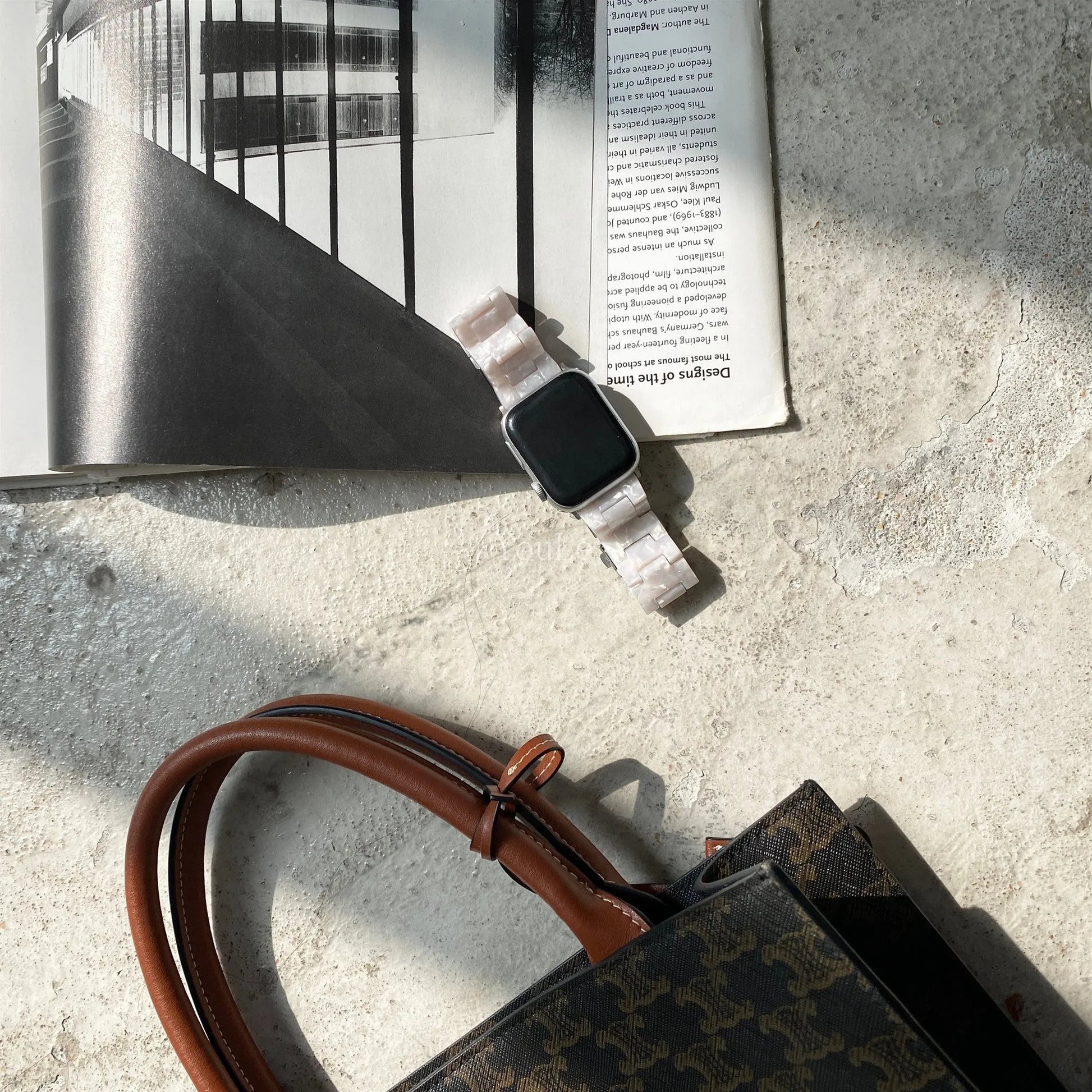 White and grey shell pattern resin Apple Watch strap on a wrist.