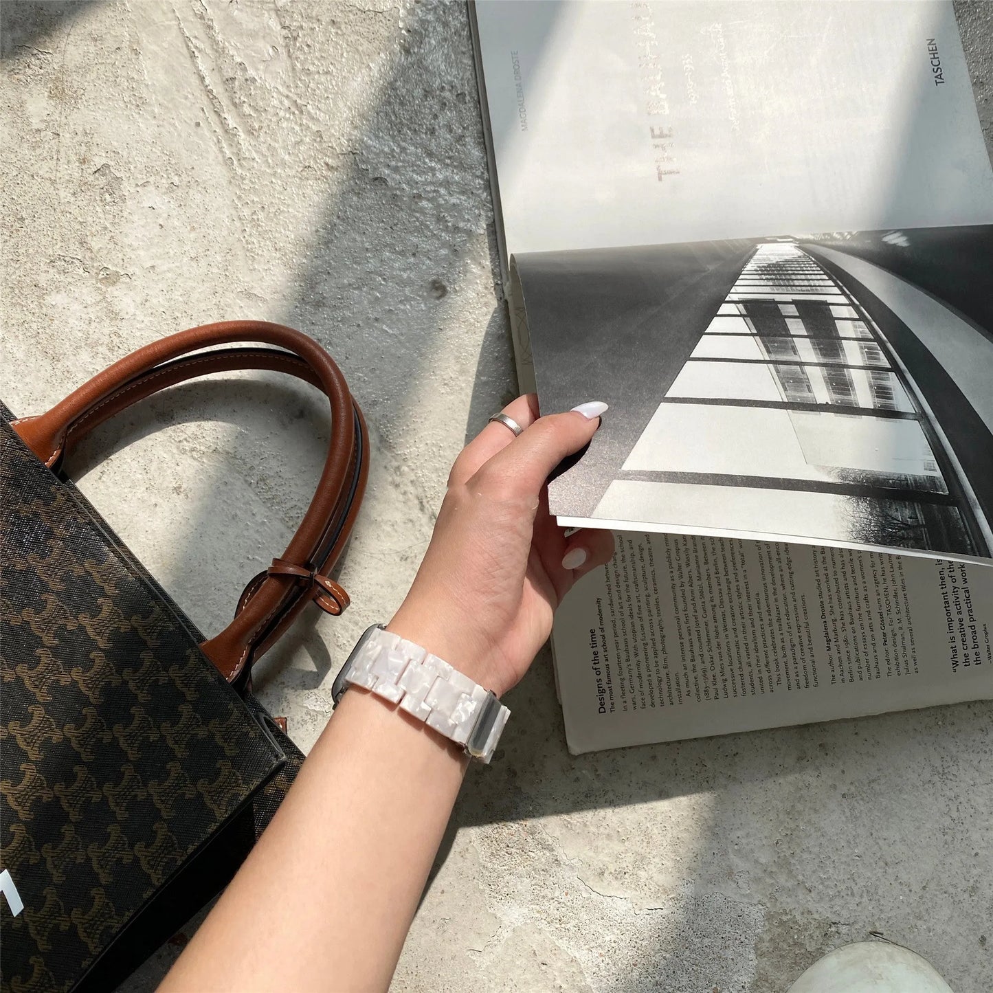 White and grey shell pattern resin Apple Watch strap on a wrist.