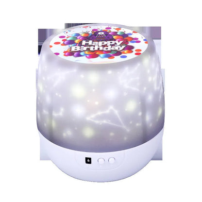 A cartoon-style starry sky projector lamp projecting constellation scenes onto a dark wall.