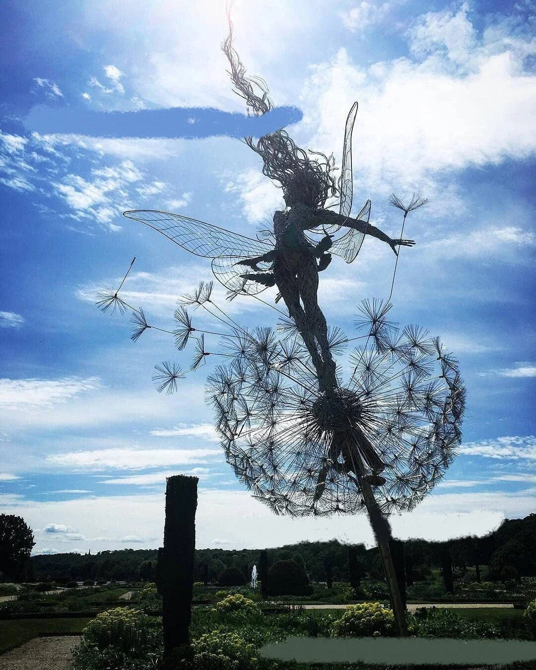 Enchanting fairy garden sculptures made of metal, featuring playful designs of fairies and pixies among dandelions and flowers.