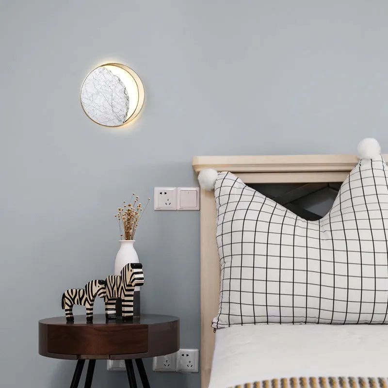 Round white marble and copper wall sconce LED light mounted on a wall