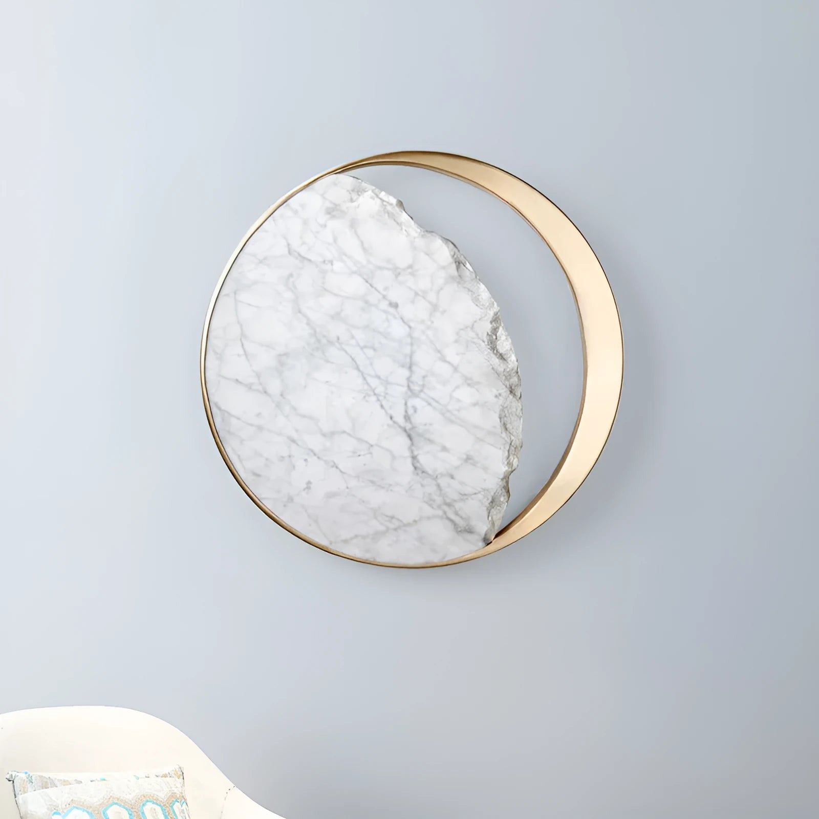 Round white marble and copper wall sconce LED light mounted on a wall