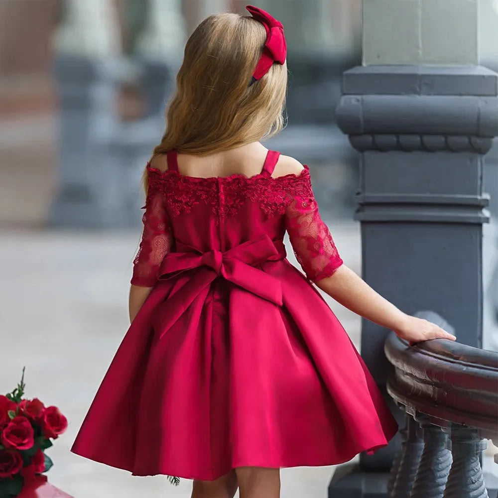 Simple children's polyester dress with lace trim in dark red, shown on a hanger.