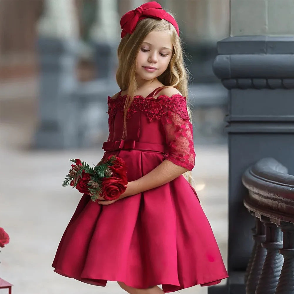 Simple children's polyester dress with lace trim in dark red, shown on a hanger.