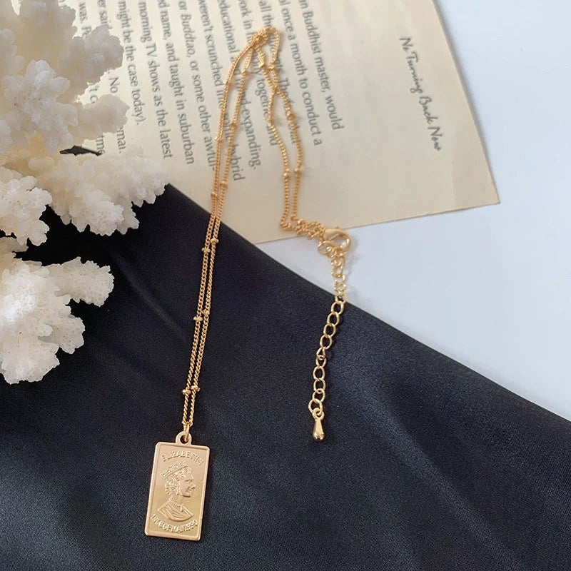 Gold alloy abstract face choker necklace with geometric pendant, adjustable length