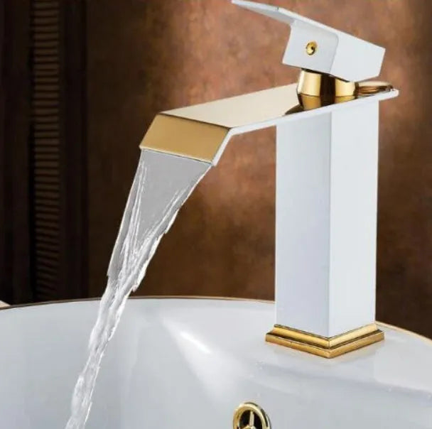 Black and white painted basin faucet with gold accents and waterfall spout design