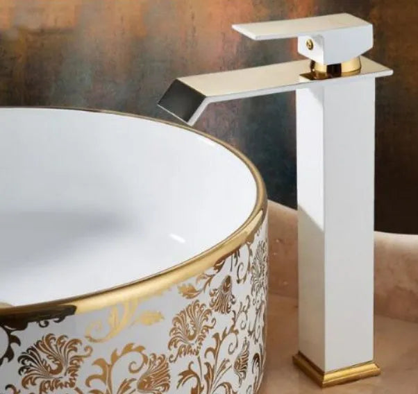 Black and white painted basin faucet with gold accents and waterfall spout design