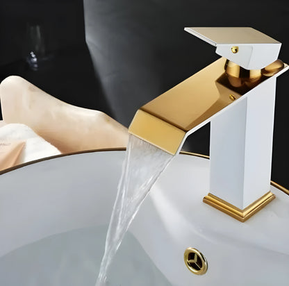 Black and white painted basin faucet with gold accents and waterfall spout design