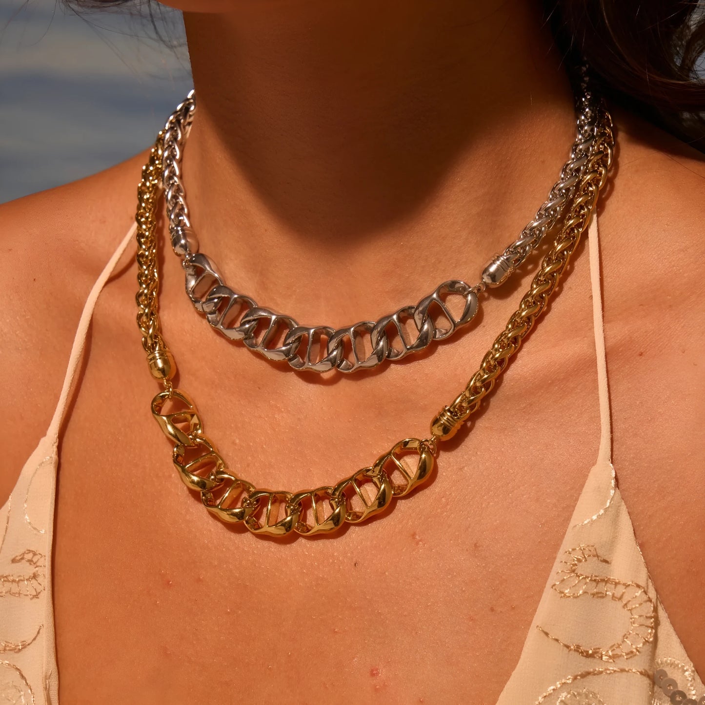 Gold plated stainless steel necklace with geometric pendant for women, shown in two colour options.