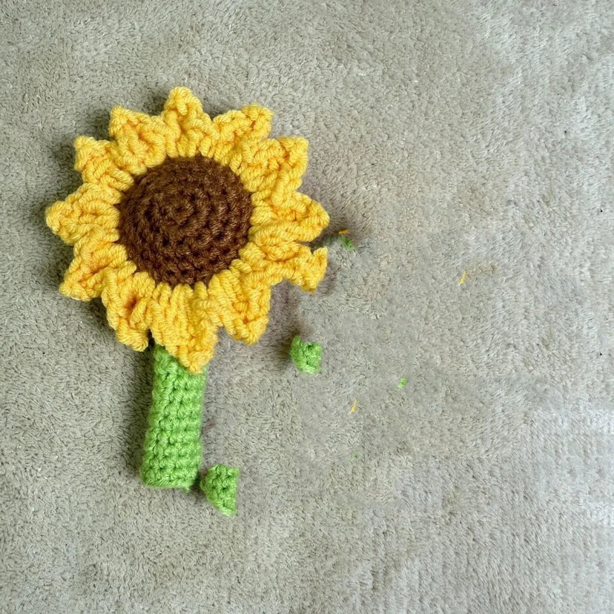 Hand-woven yellow and brown sunflower pen cover holding a pen.