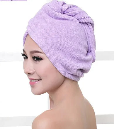 A woman wearing a sky blue microfiber hair dryer cap, with wet hair tucked inside, showing the towel's wrap-around design.