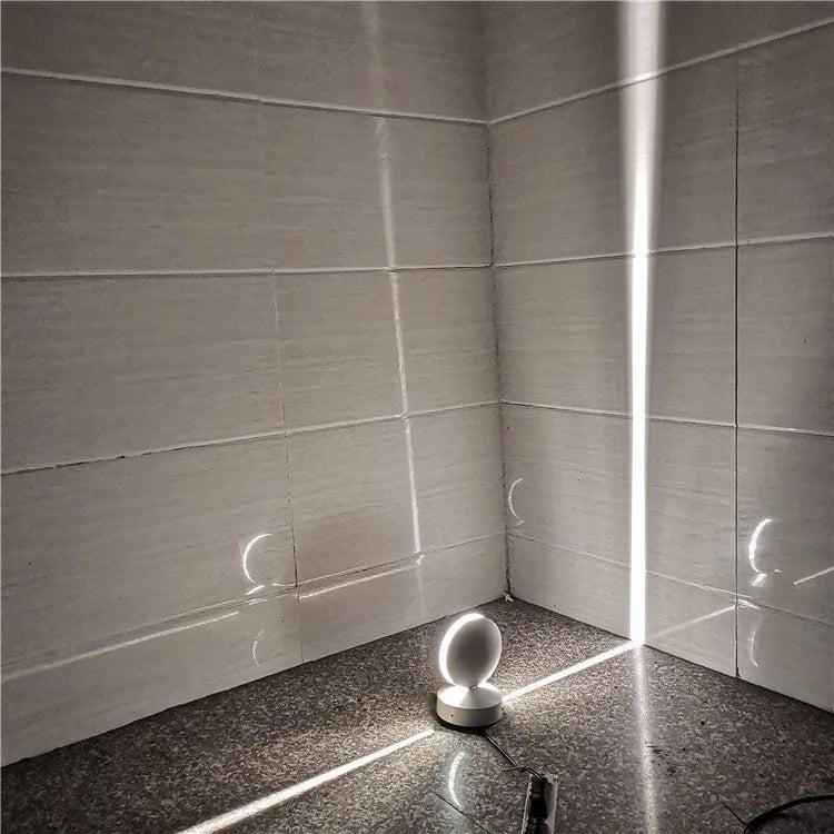 Modern linear aluminium wall spotlight bar with a glass lens, mounted as an accent light.