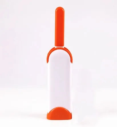 Blue reusable pet hair removal brush with double-sided head next to its self-cleaning base.