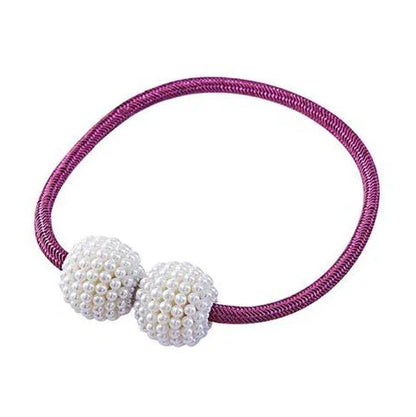 Magnetic curtain tiebacks with white pearl beads and fabric loops holding gathered curtain