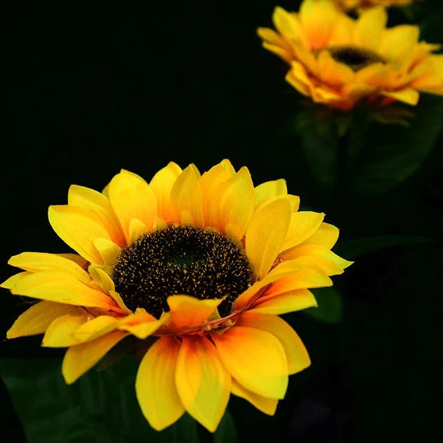 Elegant solar-powered sunflower lamps illuminating a serene outdoor garden pathway