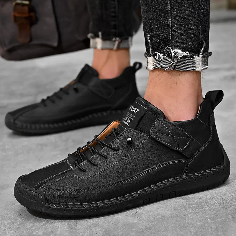 Men's black mid-top Martin boots with elastic band and sewn sole on a plain background.