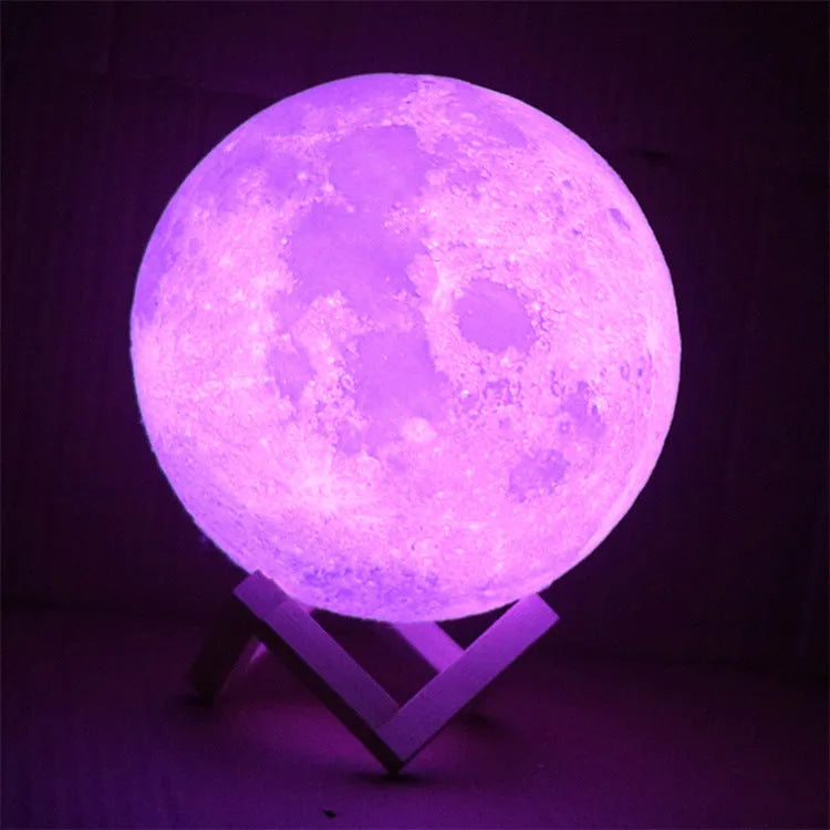 3D printed white moon lamp on a wooden holder, showing detailed crater texture and soft LED glow.