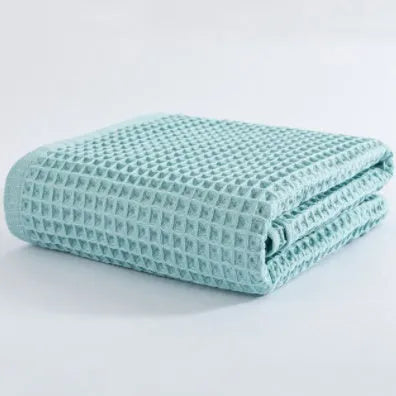 Large light-coloured cotton bath towel with a textured surface, measuring 140 by 70 centimetres.