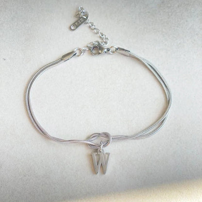 Elegant letter charm bracelets for women in gold and silver tones, featuring a delicate snake chain design and personalised letter charms.