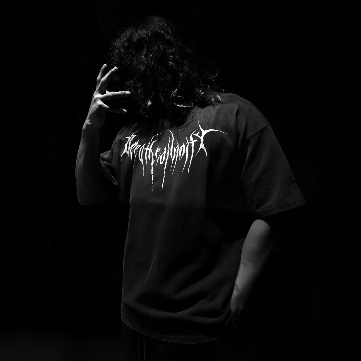 Man wearing a dark loose-fitting plus-size cotton short-sleeved T-shirt with gilding details.