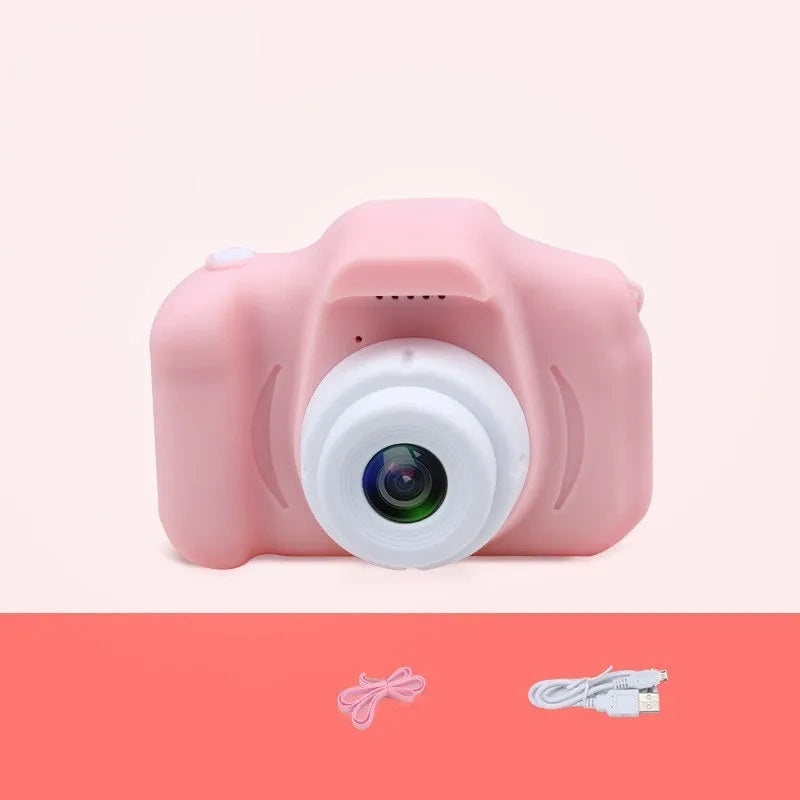 X2 HD mini digital camera for kids in silicone case with lanyard, shown capturing photo on 2-inch screen.